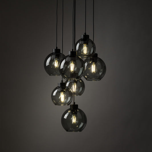 Chandelier with glass shades and visible bulbs against a dark background