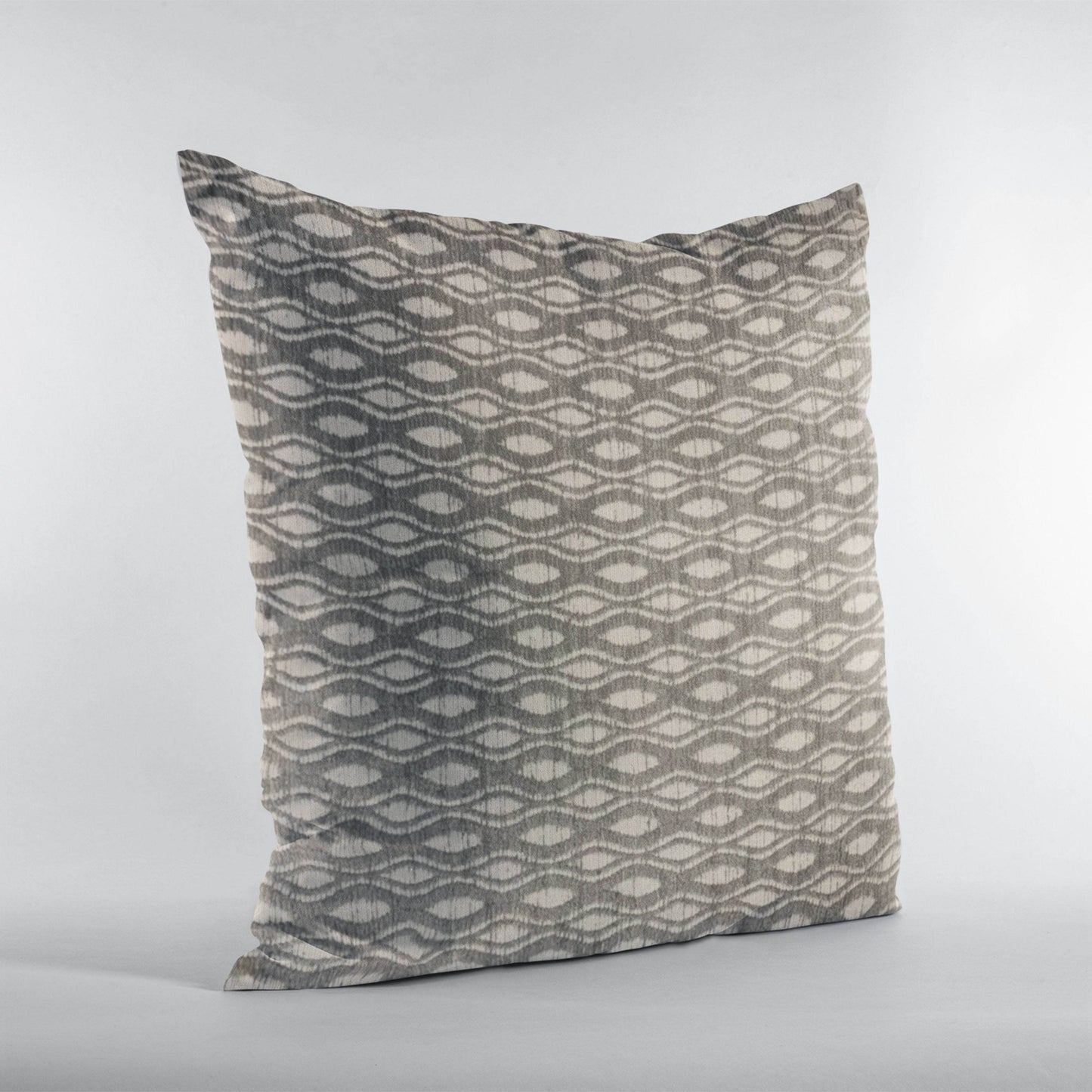 Decorative pillow with geometric pattern on a light gray background