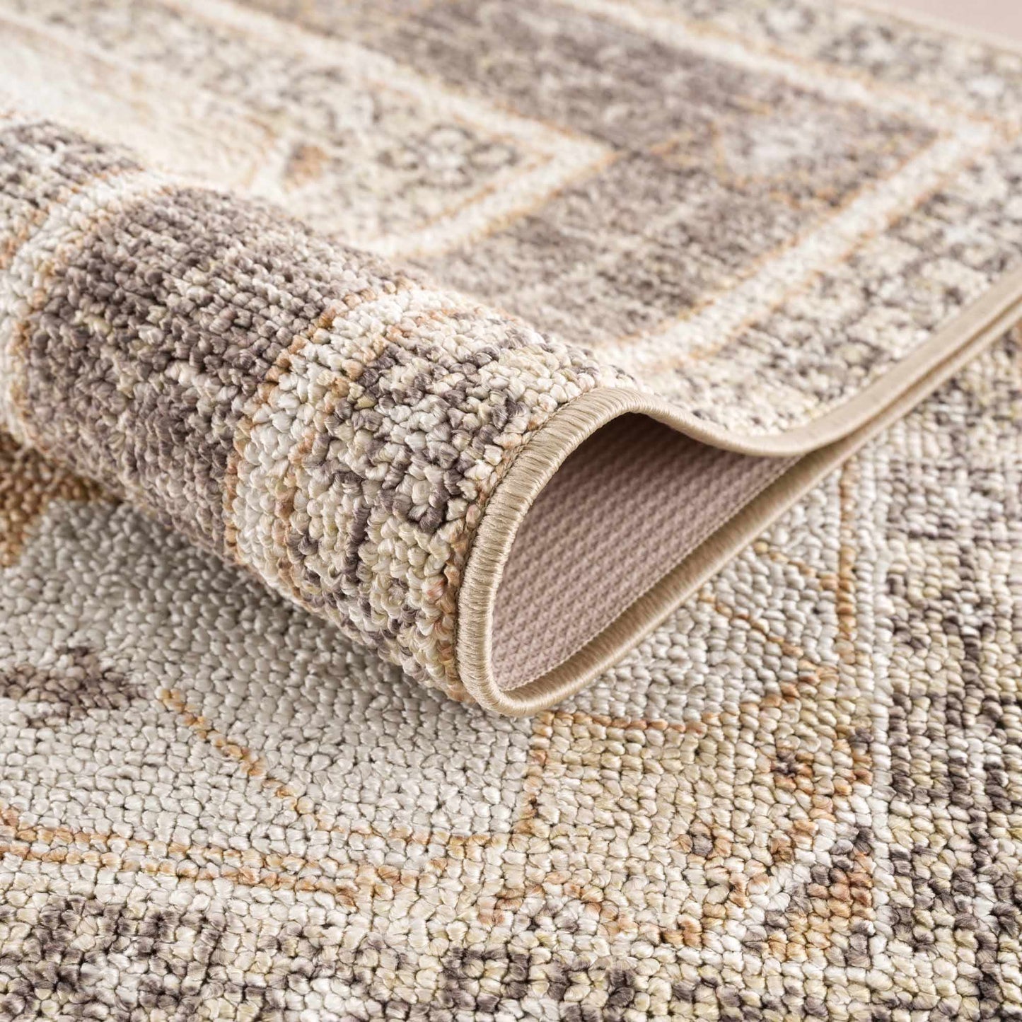 Close-up of a textured beige and brown area rug with a geometric pattern.