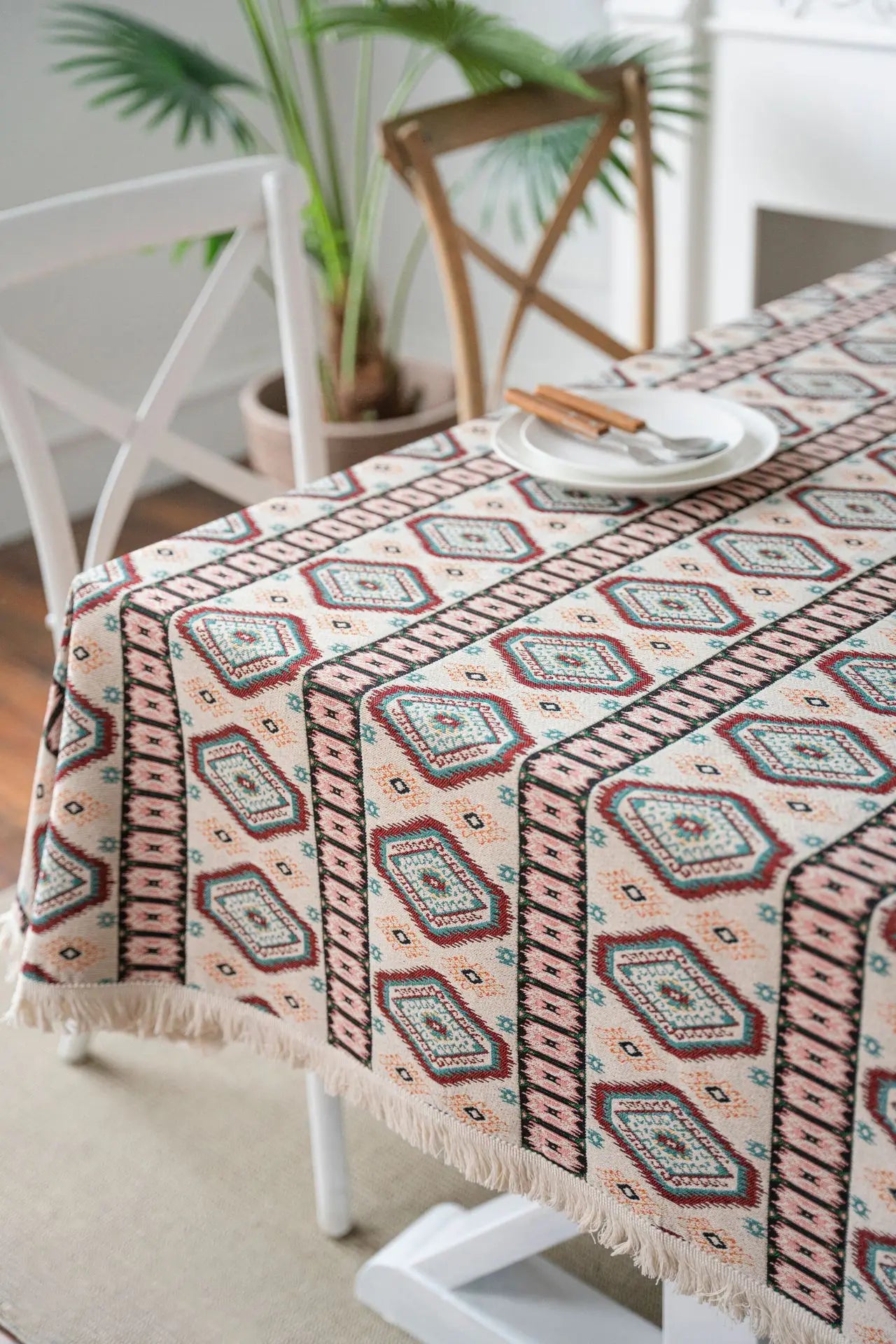 Close-up detail of woven diamond pattern in cream, rose, teal, and sand with fringe