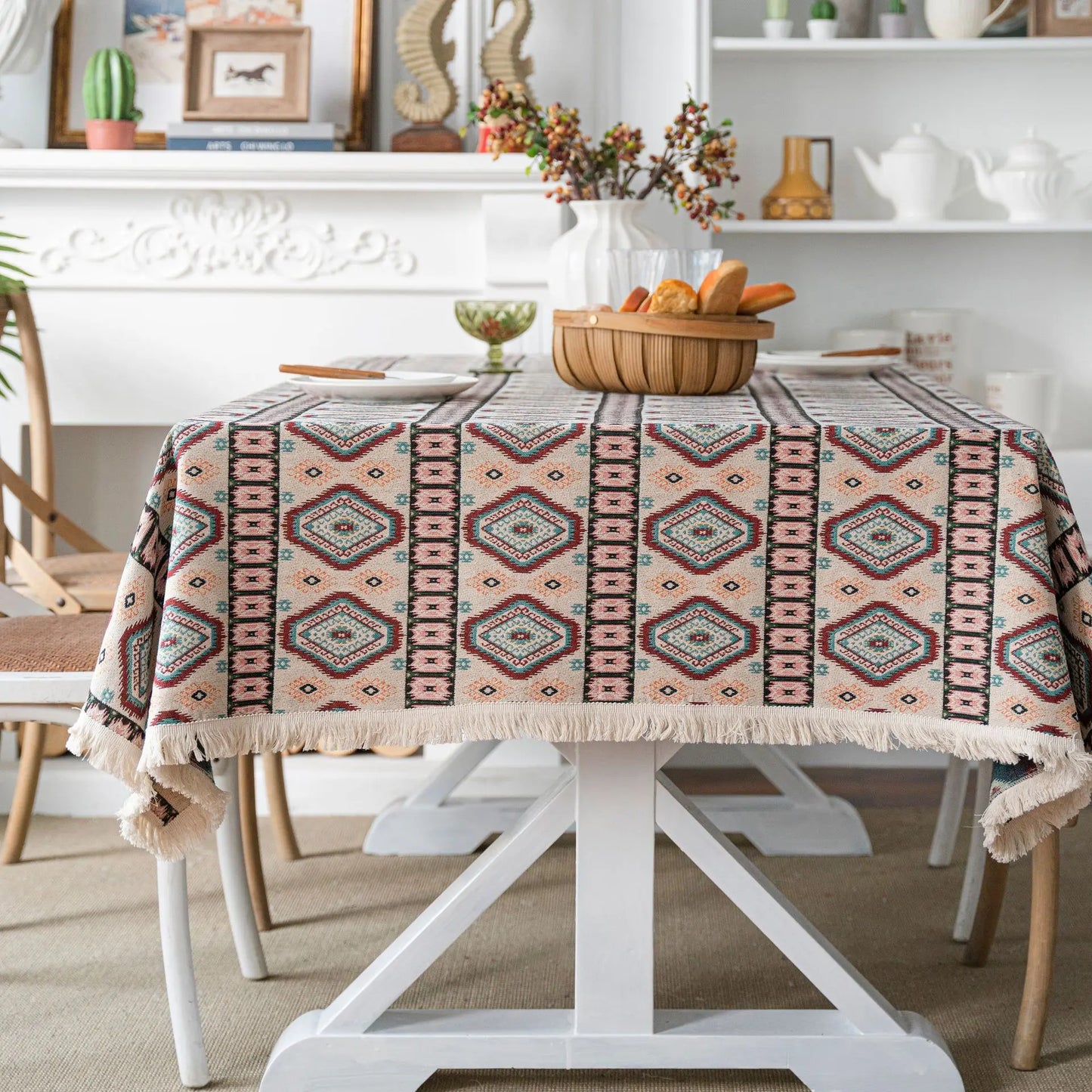 Side of woven diamond pattern in cream, rose, teal, and sand with fringe