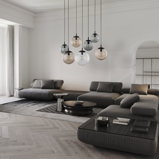 Modern Scandinavian living room with gray sectional sofa, round coffee table, and pendant lights.