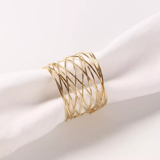Gold napkin ring on a white fabric napkin with while background