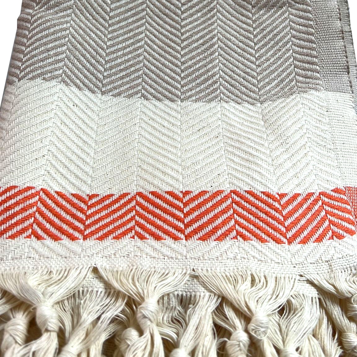 Close-up of herringbone weave and rust-colored accent stripe with hand-knotted fringe