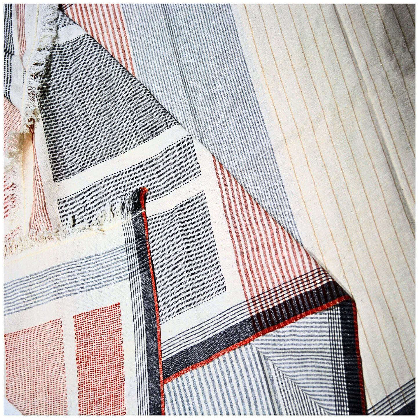A soft, cozy cotton throw blanket with a minimalist striped design and fringed edges.