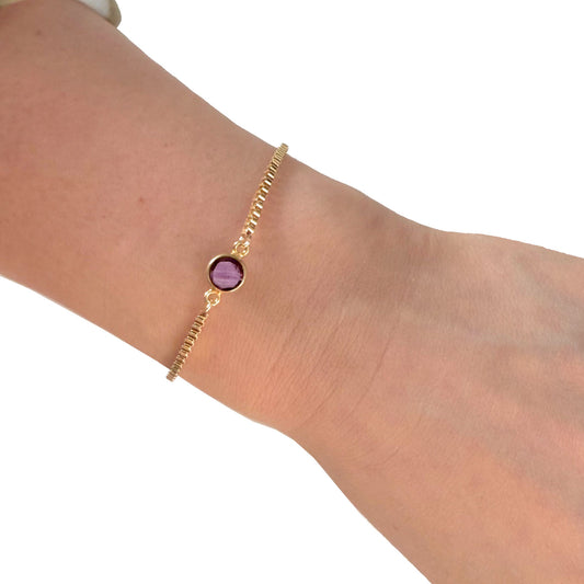 Amethyst gemstone bracelet worn on wrist with gold chain