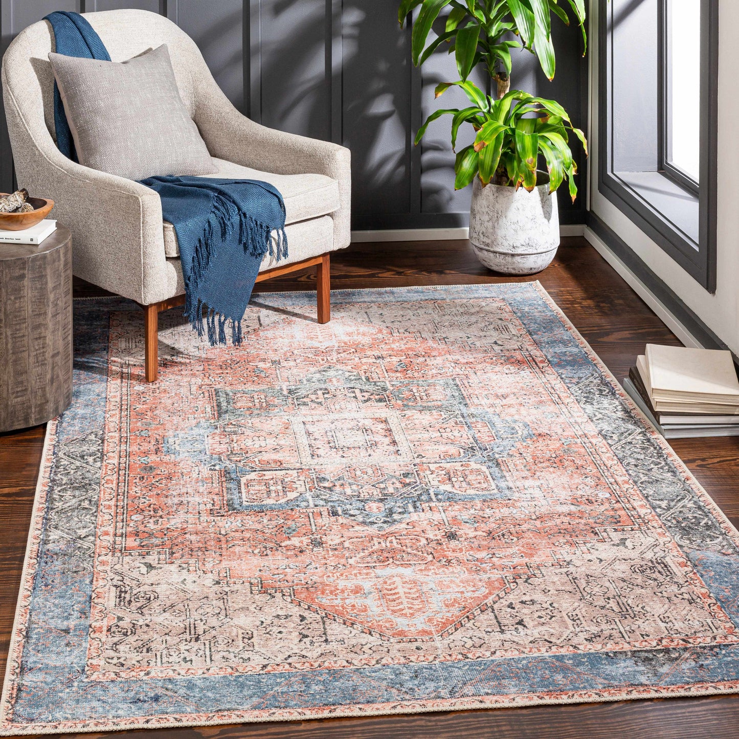 Living room with a patterned rug, armchair, and plant