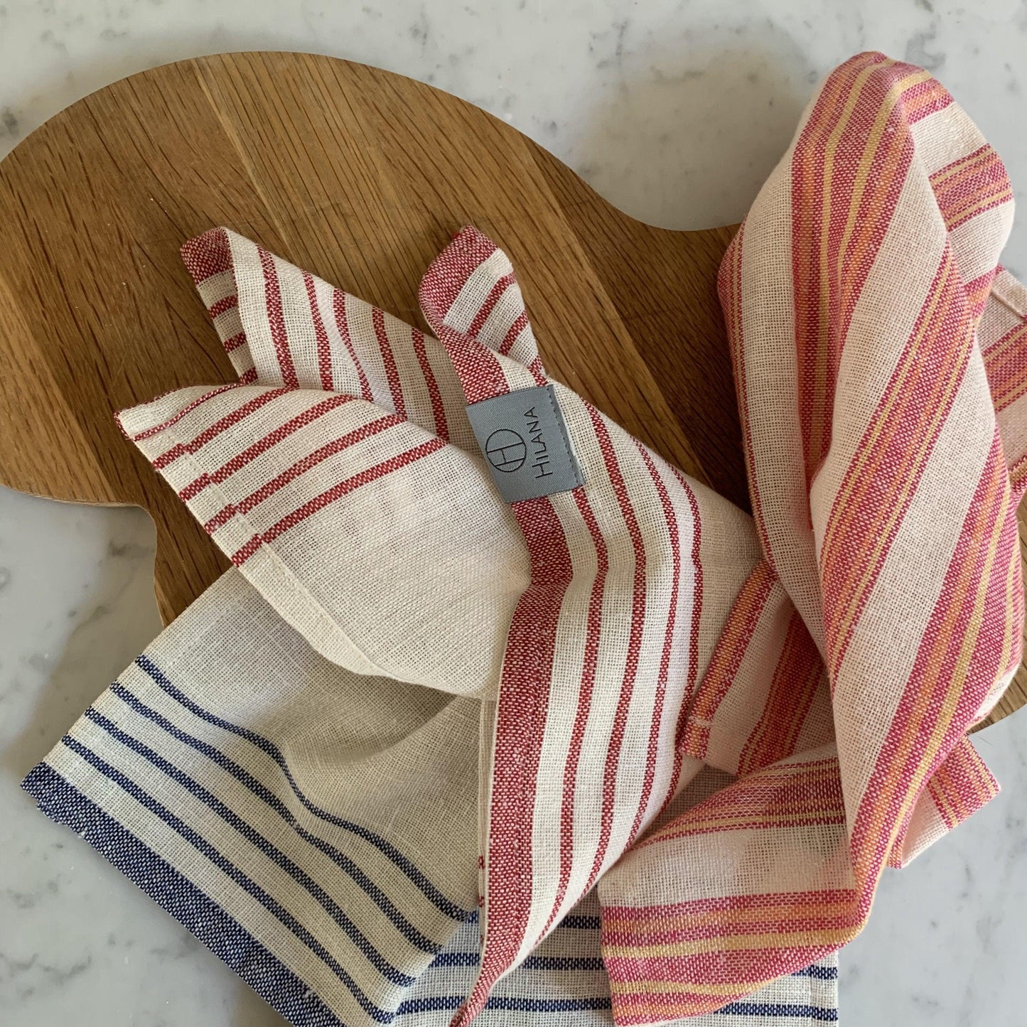 Eco-friendly Mediterranean-style magenta striped tablecloth set with matching napkins, made from 50% recycled cotton.