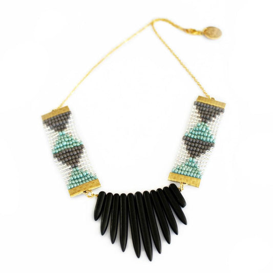 Handmade Shh by Sadie necklace with a geometric pattern of teal, black, and white beads, complemented by black howlite stone spikes and a signature tag. Perfect for layering or wearing solo.