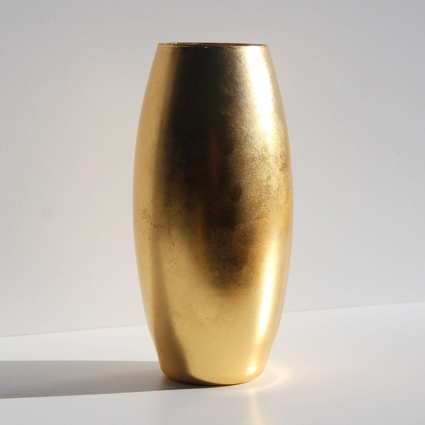 Handcrafted 10-inch gold gilded flower vase with a modern distressed finish, mouth-blown glass design, and elegant metallic leaf detailing.