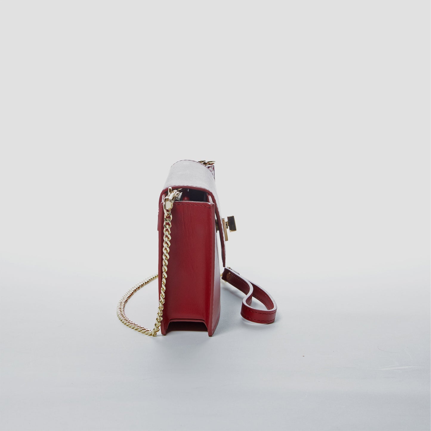Side profile of the Mary Mini Burgundy Leather Crossbody Bag showing slim structured silhouette.