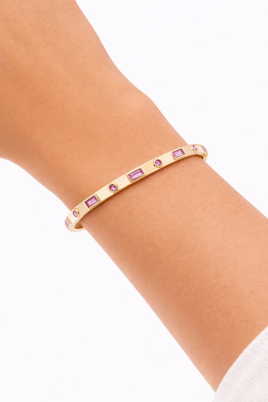 Pink topaz gold bangle bracelet worn on wrist