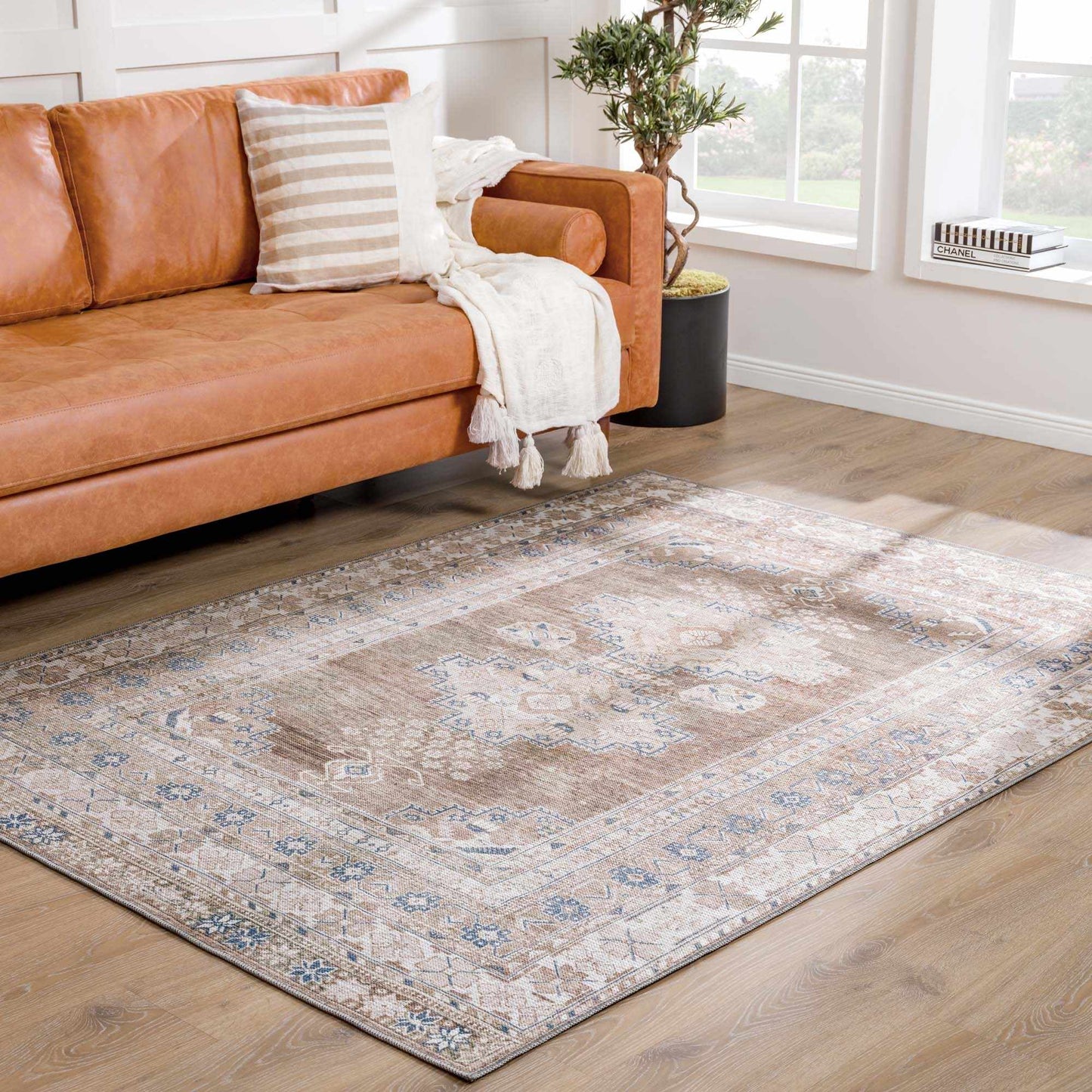 Baltinglass rug styled in a living room with leather sofa and striped pillow