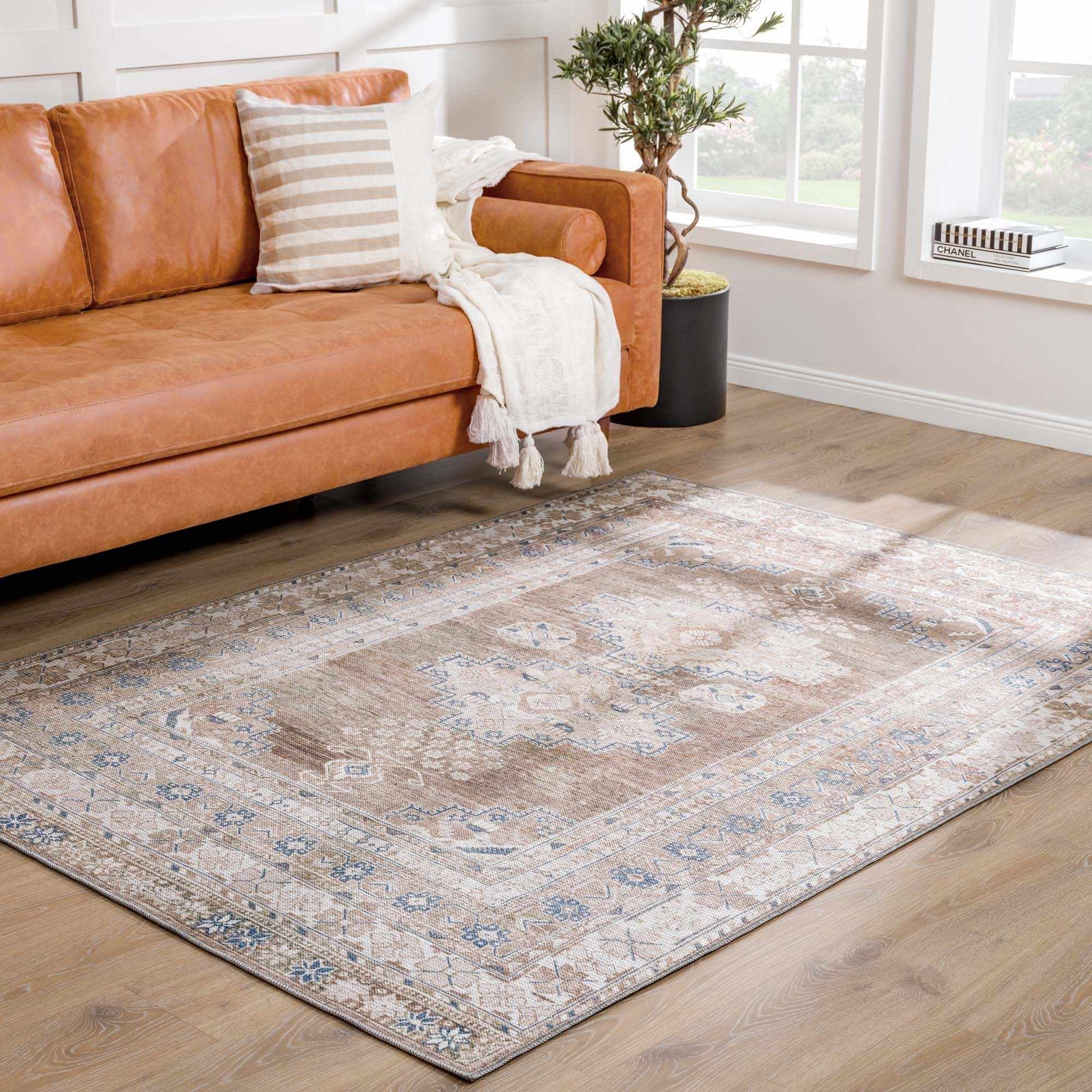 Baltinglass rug styled in a living room with leather sofa and striped pillow