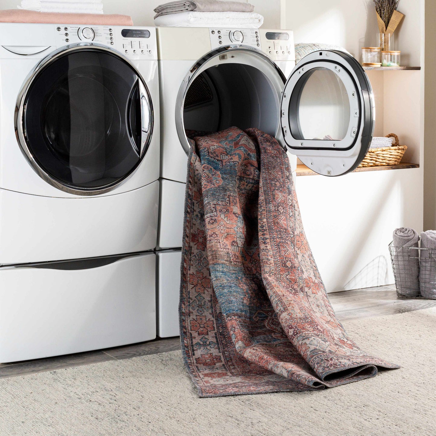 Laundry room with a washing machine and dryer, and a patterned rug draped over the dryer.