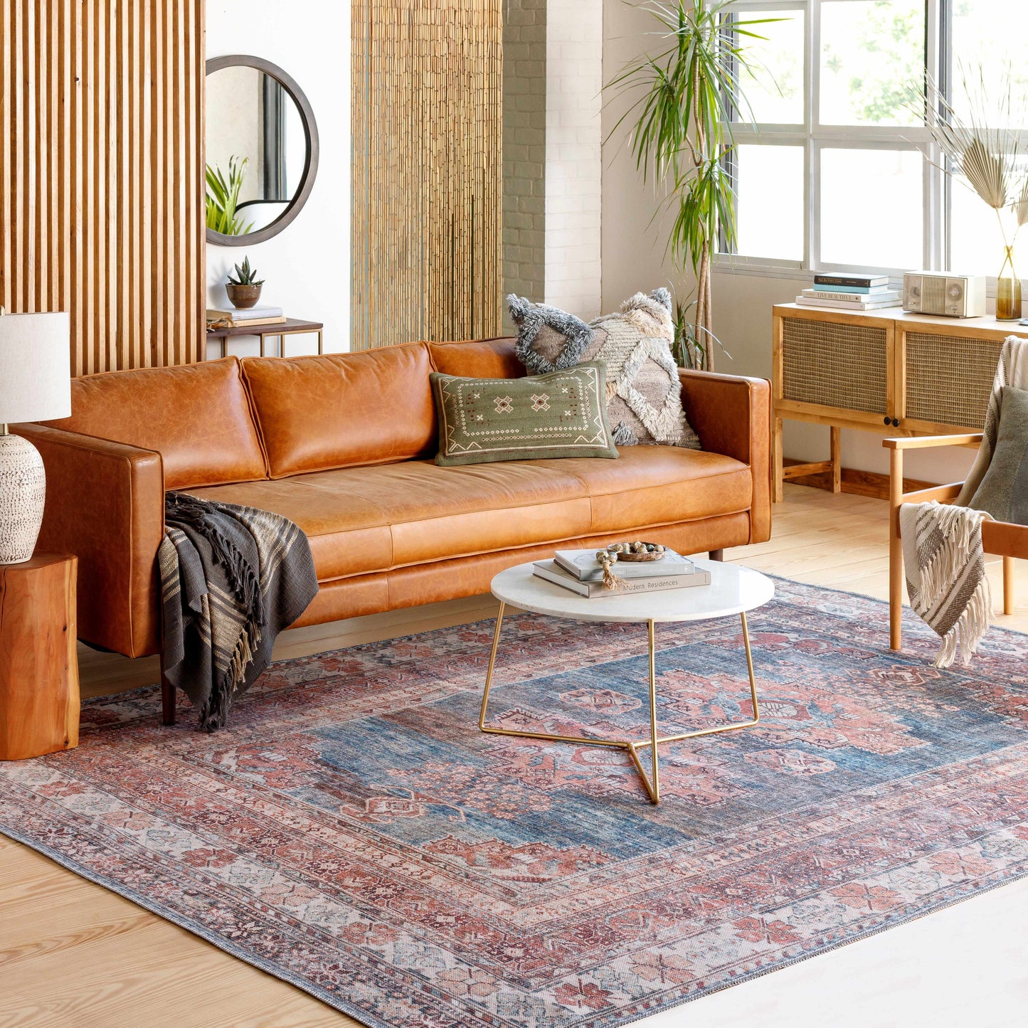 Living room with a brown leather sofa, coffee table, and decorative rug.