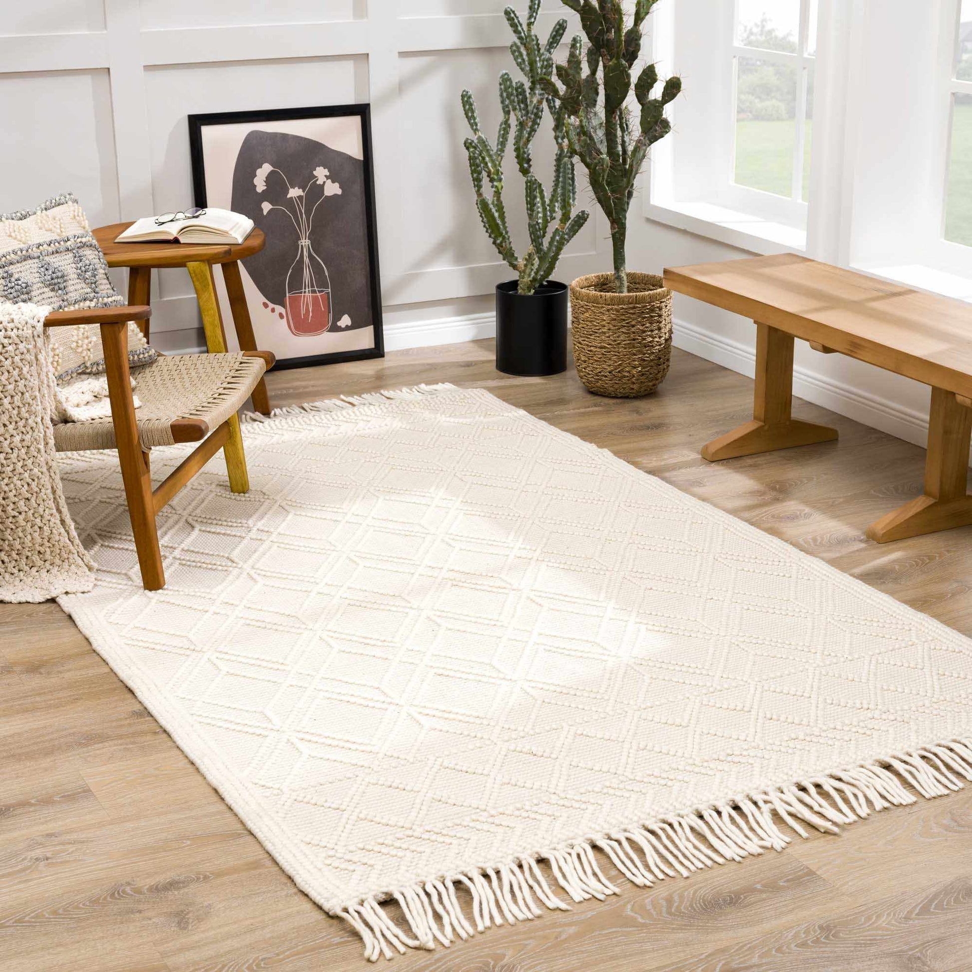 White textured rug with fringe on a wooden floor in a room with furniture and decor.