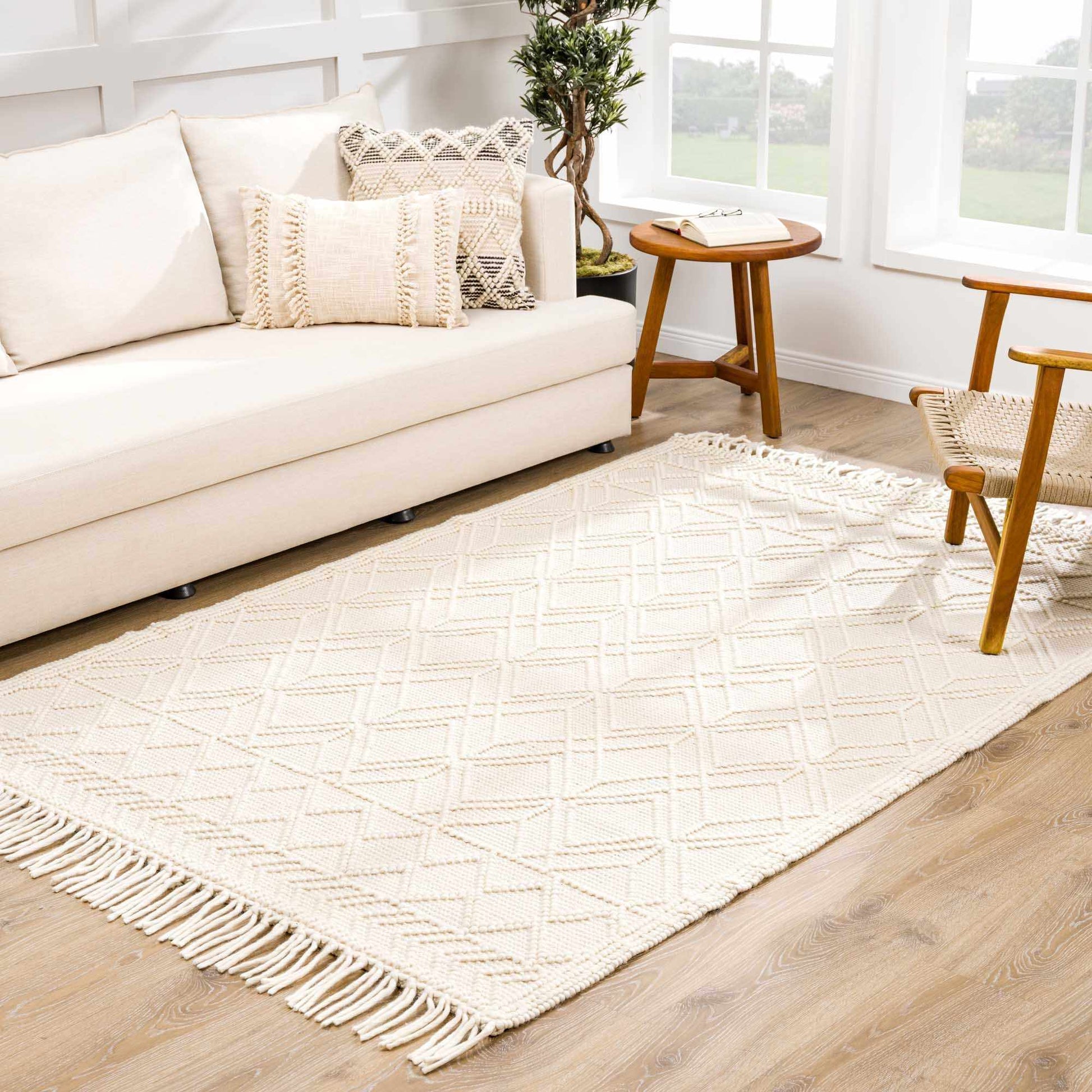 Living room with a beige sofa, rug, and wooden chair.