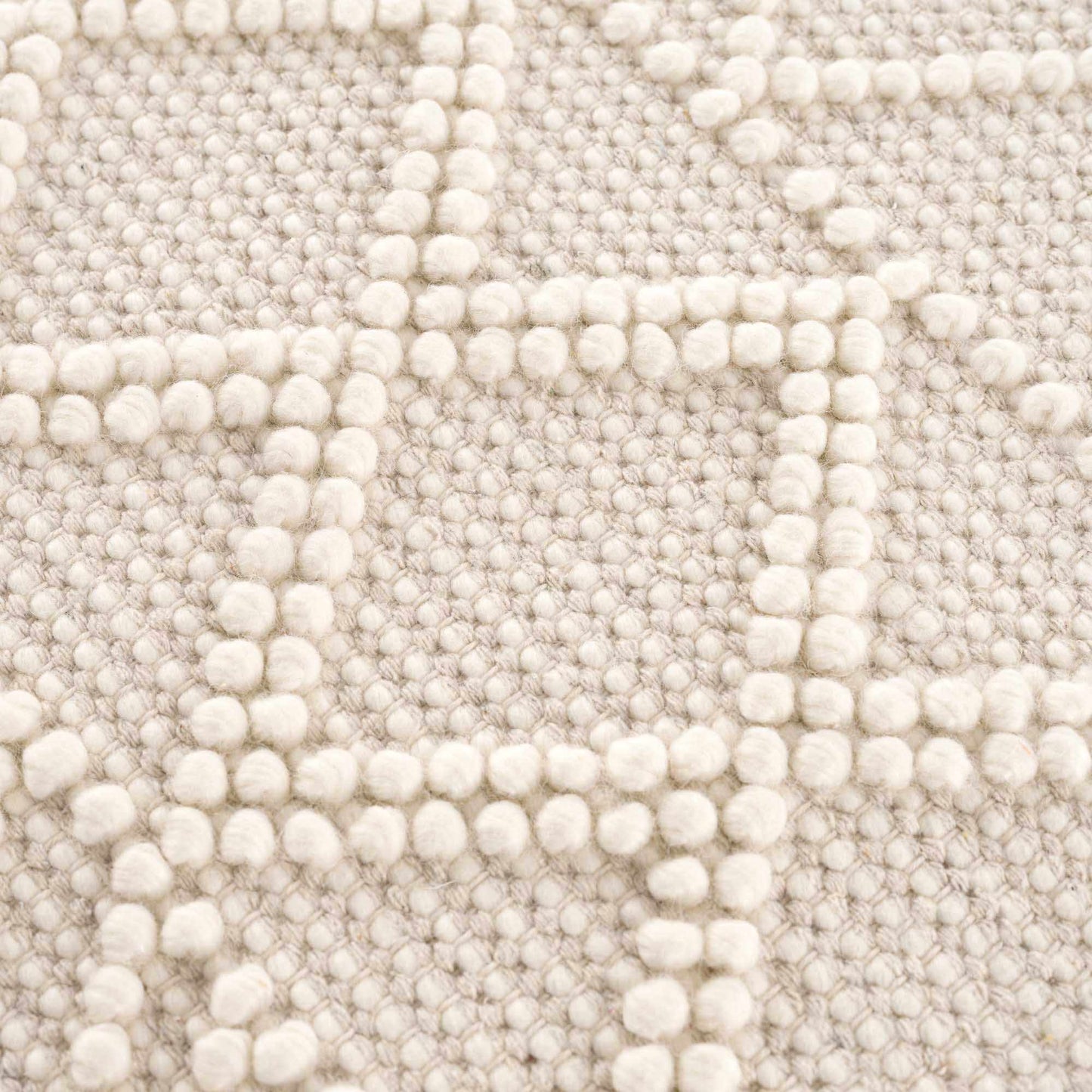 Close-up of a textured beige fabric with a subtle pattern