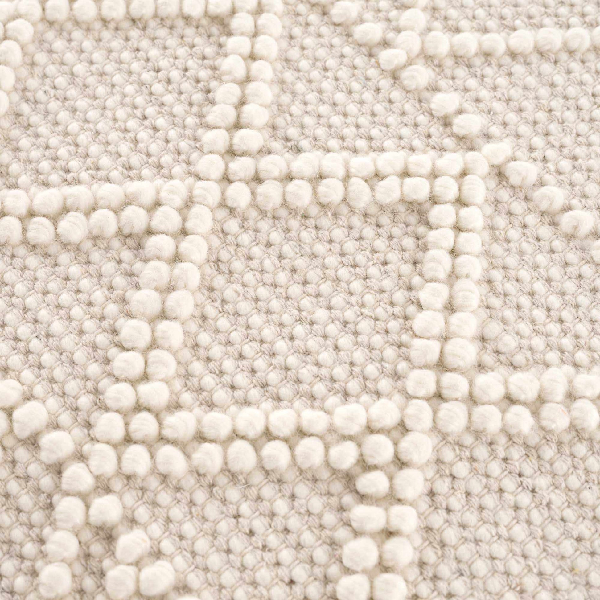 Close-up of a textured beige fabric with a subtle pattern