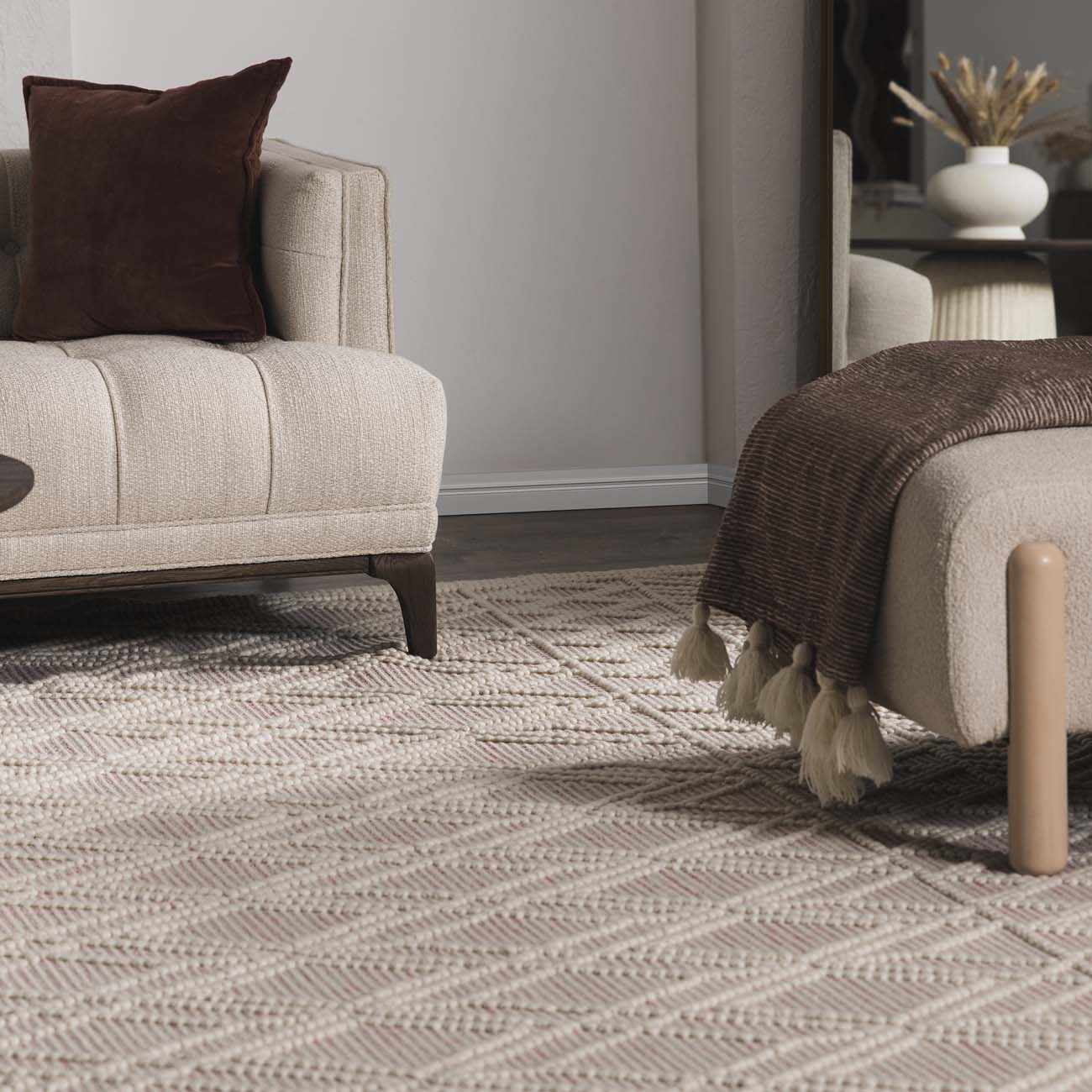 Living room with a patterned rug, beige sofa, and brown armchair.