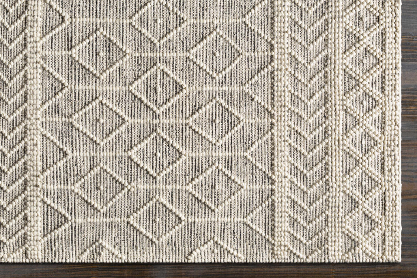 Textured area rug with geometric pattern on a wooden floor