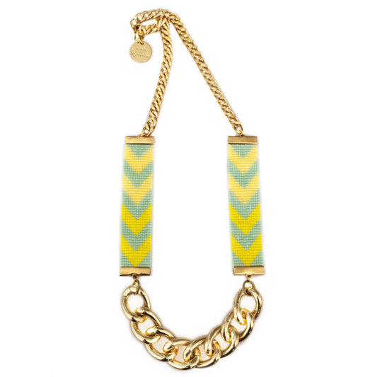 Necklace with gold chain and chevron patterned pendants on a white background