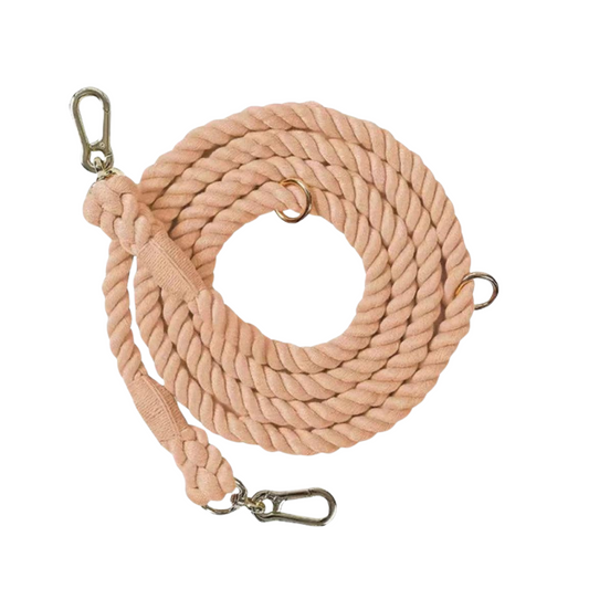 Coral-colored hand-dyed cotton rope dog leash with adjustable O-rings for hands-free walking. A durable and stylish leash for everyday use.