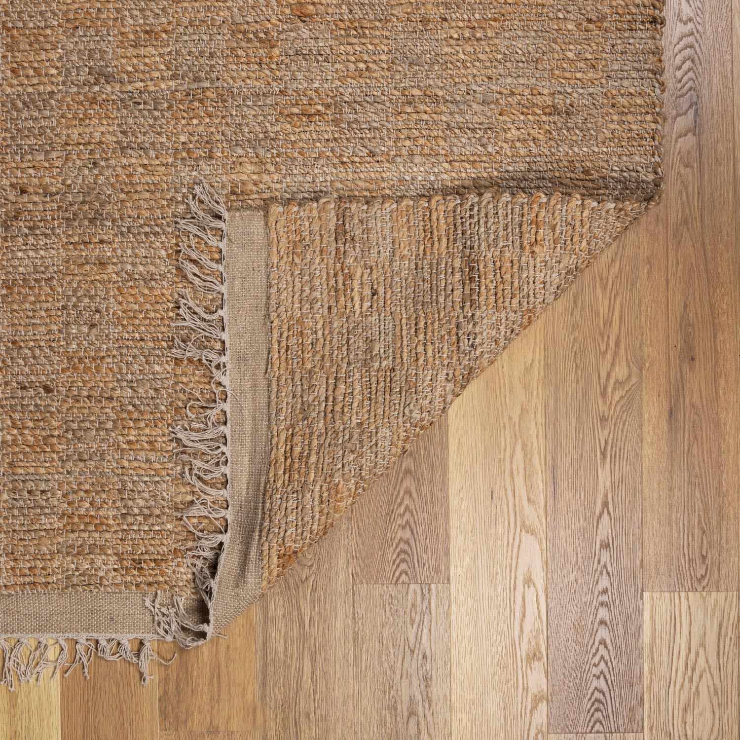 Textured area rug with fringes on a wooden floor