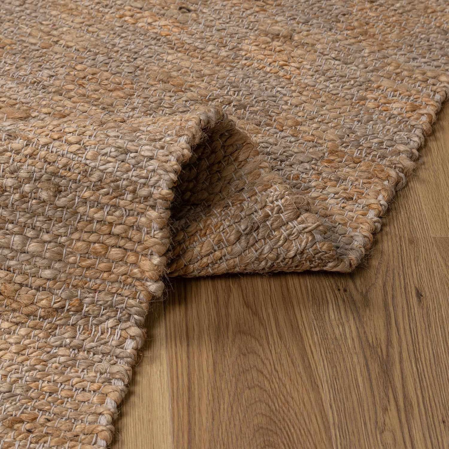 Textured beige rug on a wooden floor