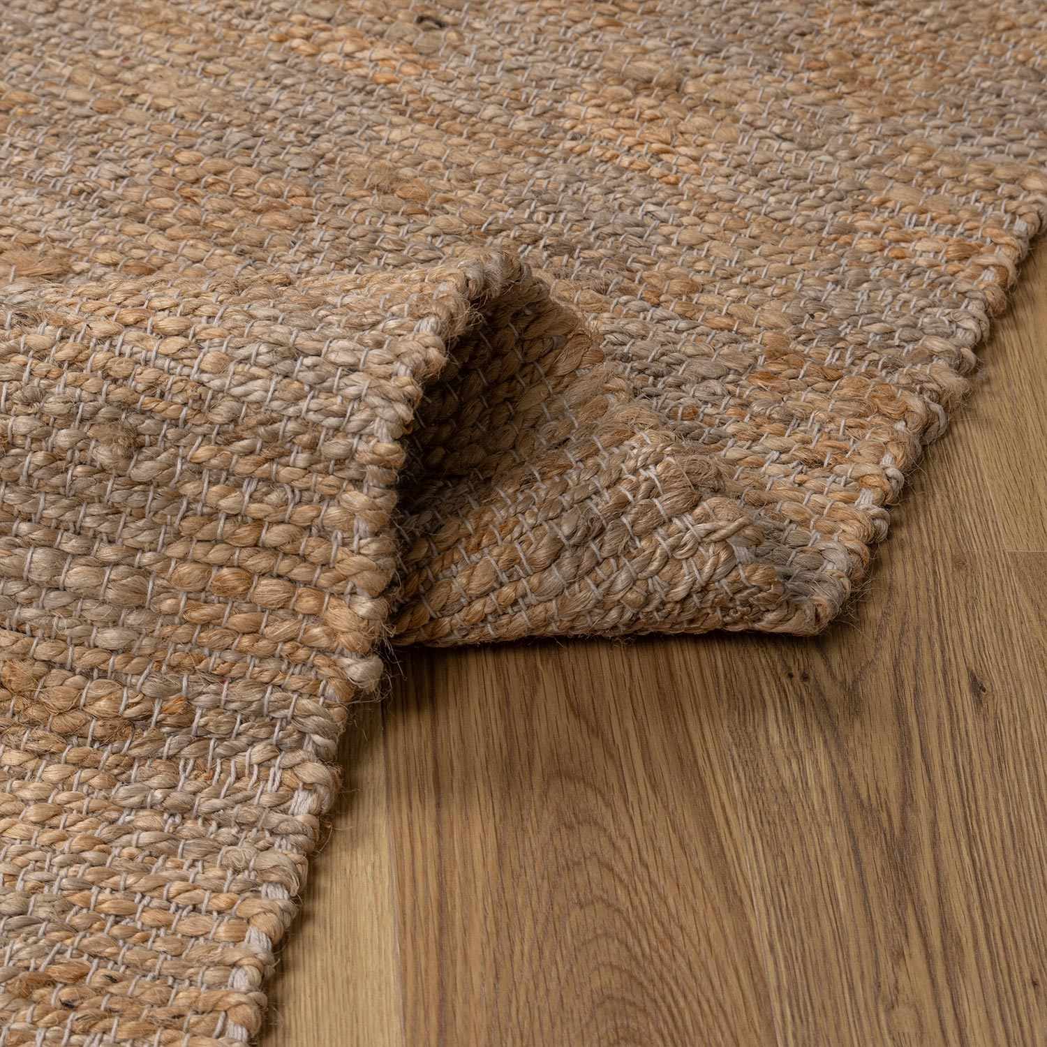 Textured beige rug on a wooden floor
