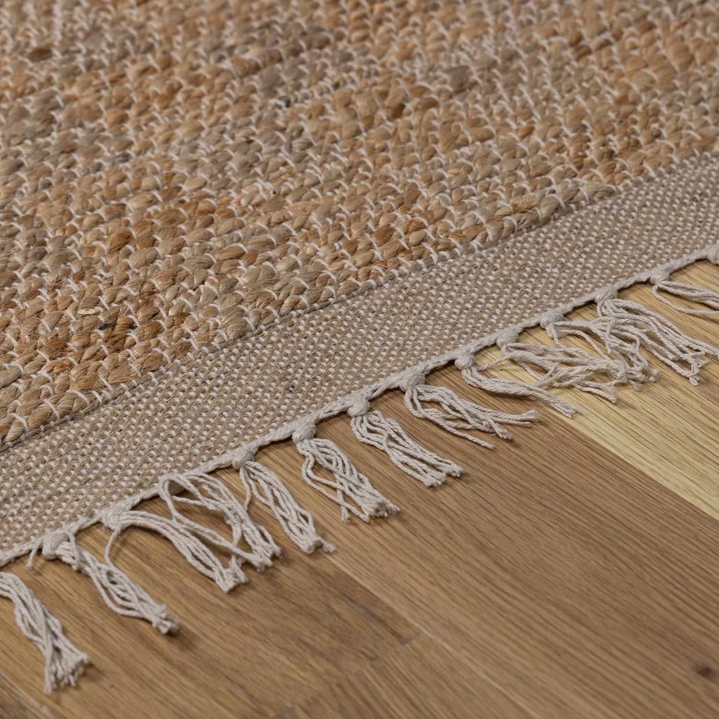 Textured woven rug with fringes on a wooden floor