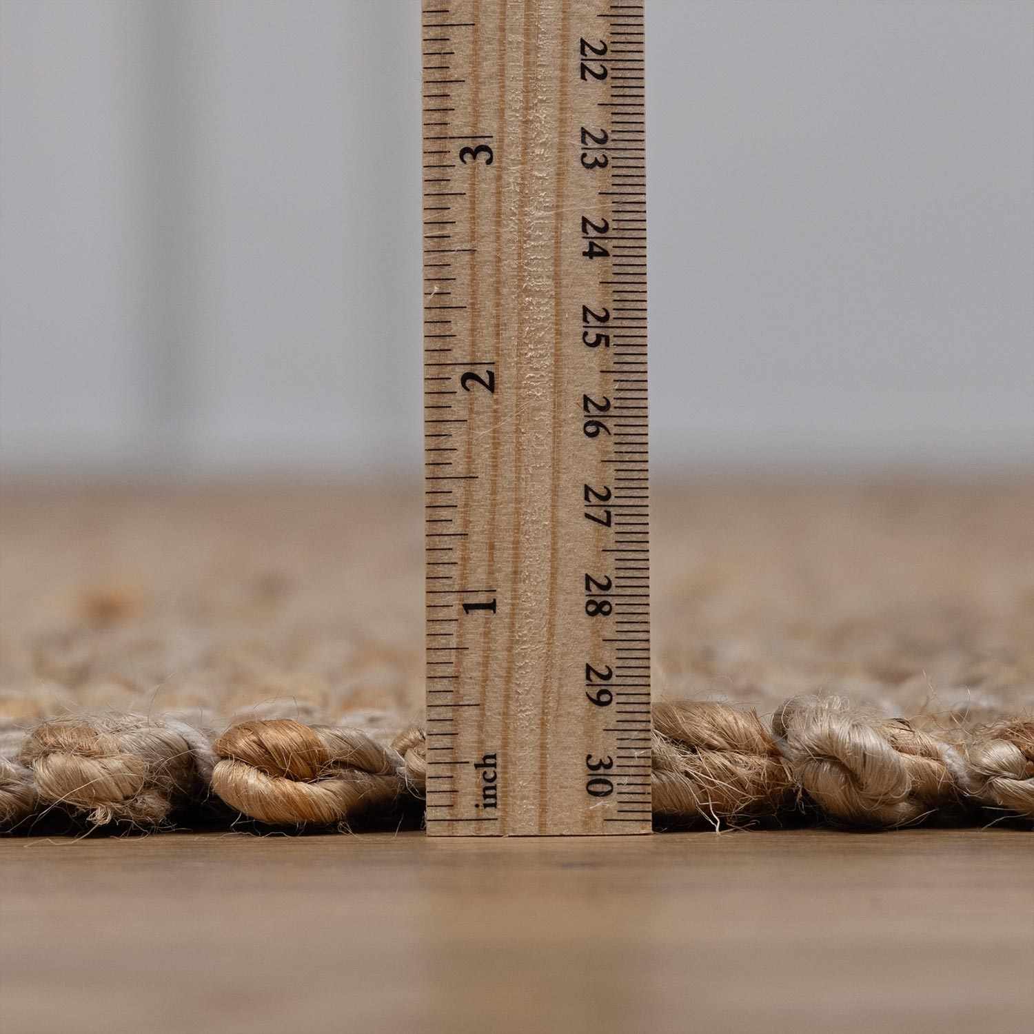 Ruler next to a piece of rope on a neutral background