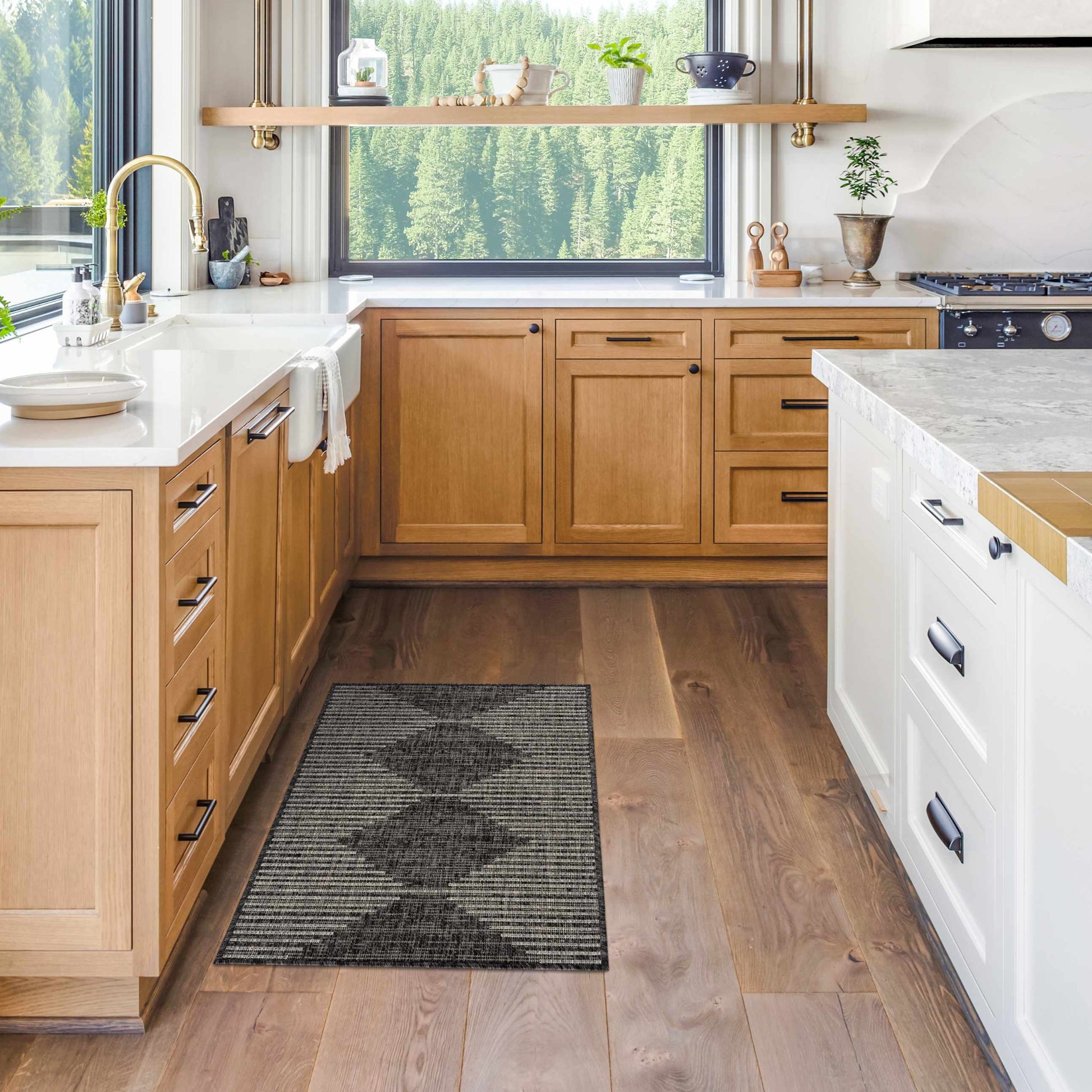 Modern kitchen with wooden cabinets, white countertops, and a window view of greenery.