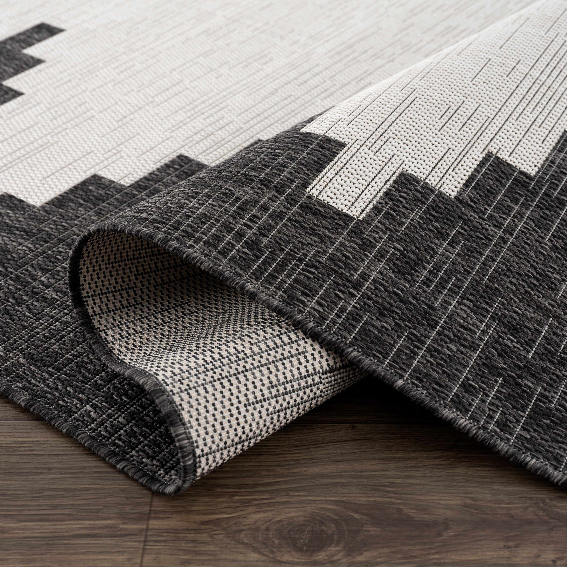 Gray and white geometric patterned rug on a wooden floor