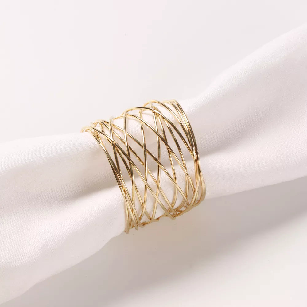 Gold napkin ring on a white fabric napkin with while background