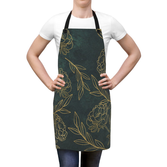 Green floral apron with gold peony print and adjustable straps, worn by a woman.