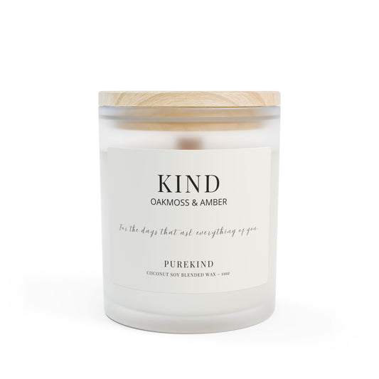 White candle with wooden lid labeled 'Kind Oakmoss & Amber' on a white background