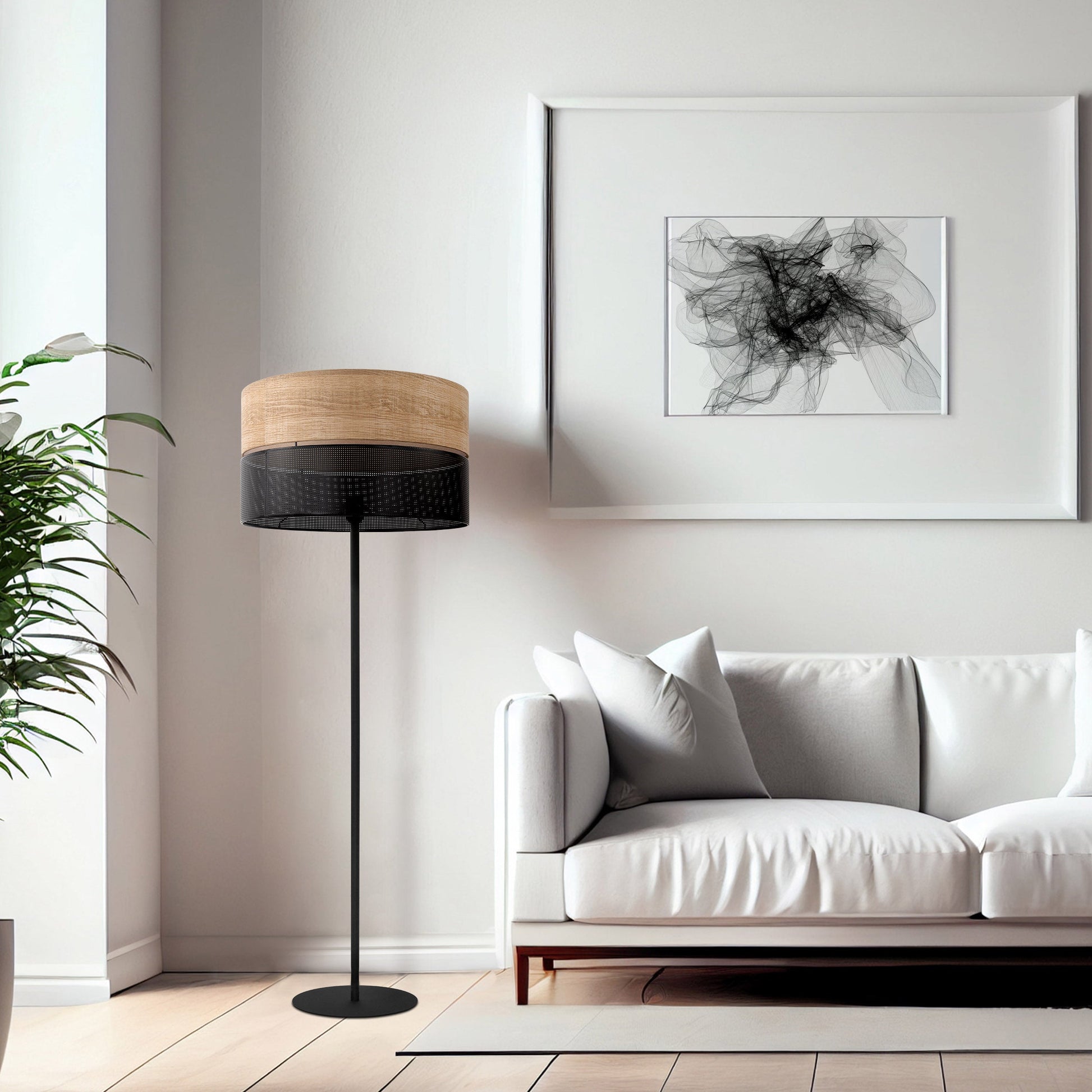 Modern living room with a white sofa, floor lamp, and abstract art on the wall.