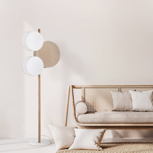 Modern living room with a floor lamp and a sofa against a light wall.