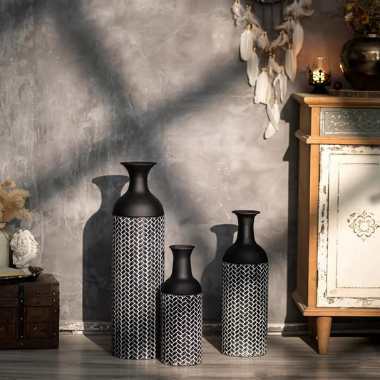 Set of three black metal floor vases.