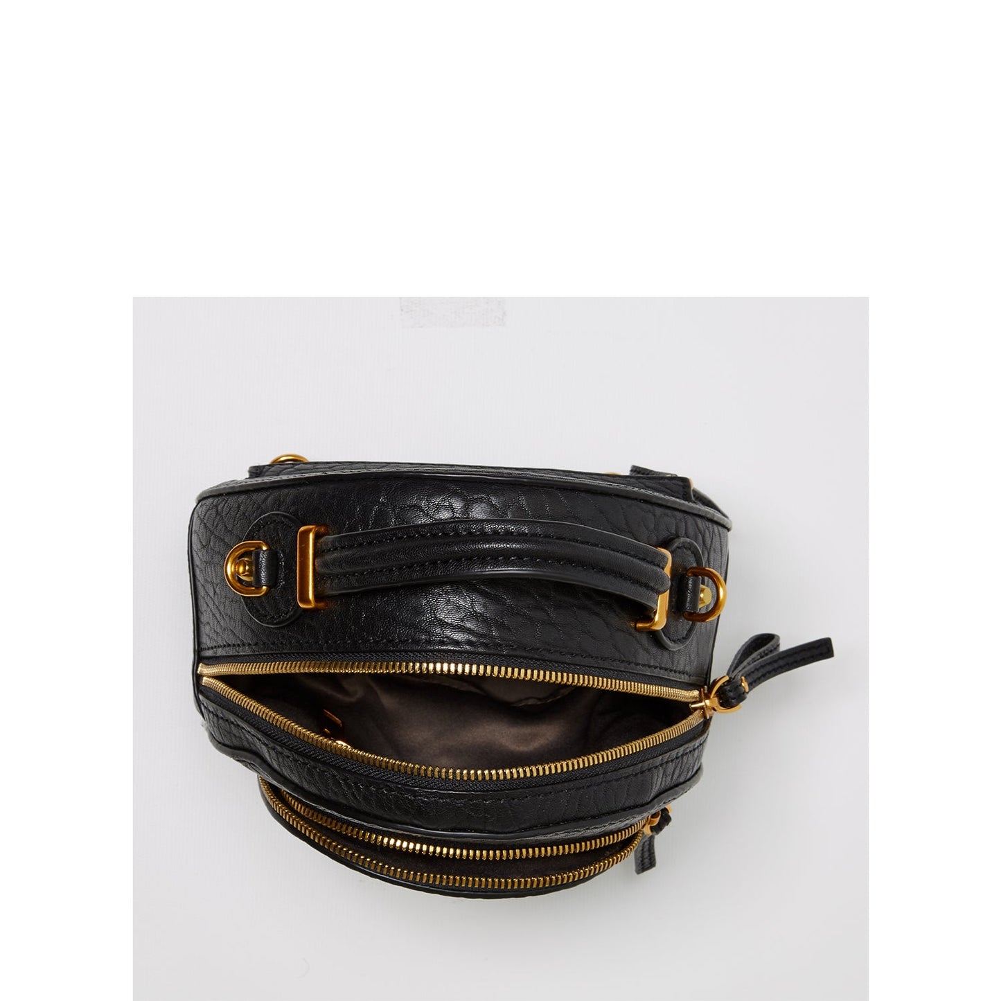 Black leather bag with gold zippers and hardware on a white background
