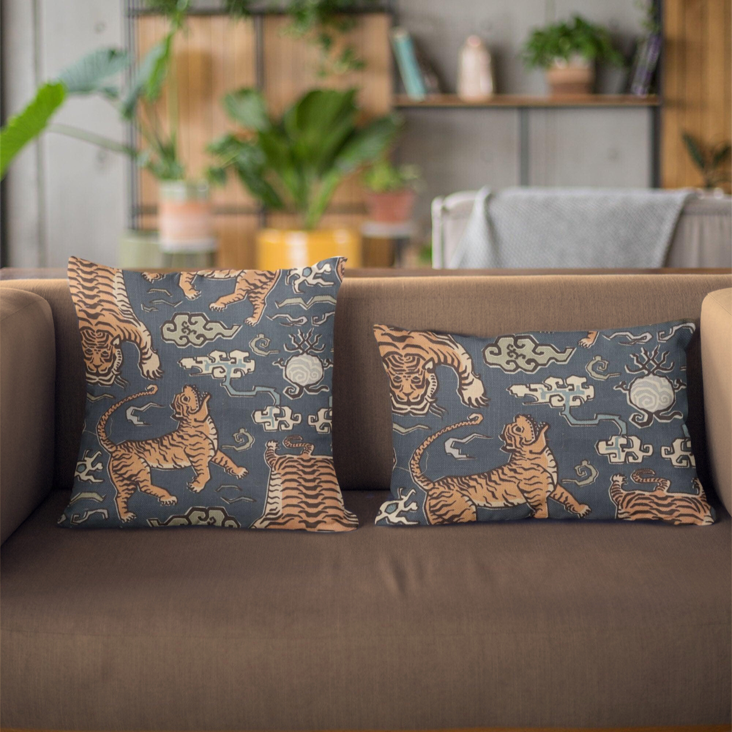 Two decorative pillows with tiger patterns on a brown sofa in a living room setting.