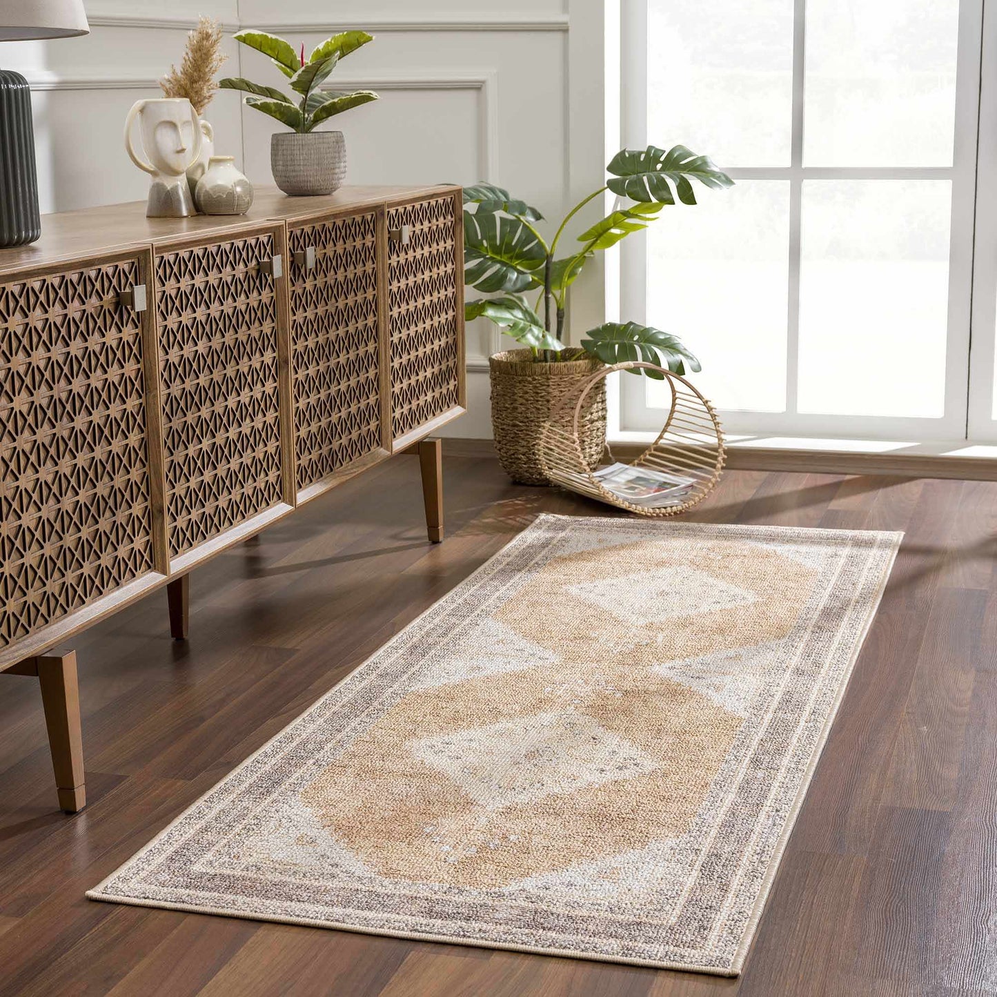 Warm brown and cream runner rug with medallion design styled in a bright hallway with wood floors.