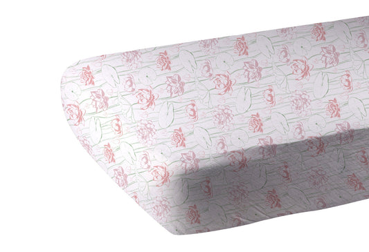 Water lily bamboo crib sheet with pink and green floral pattern on crib mattress.