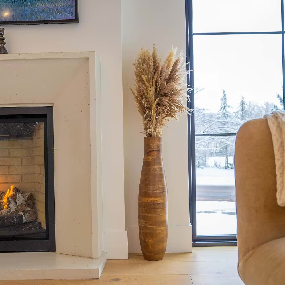 Tall wooden floor vase placed in a living room, styled with pampas grass for a warm, organic touch.