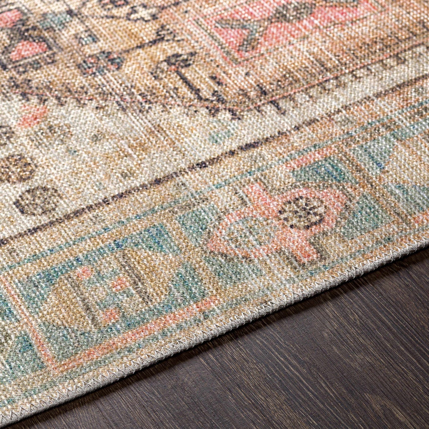 Close-up of a patterned rug with multicolor design on a wooden floor.