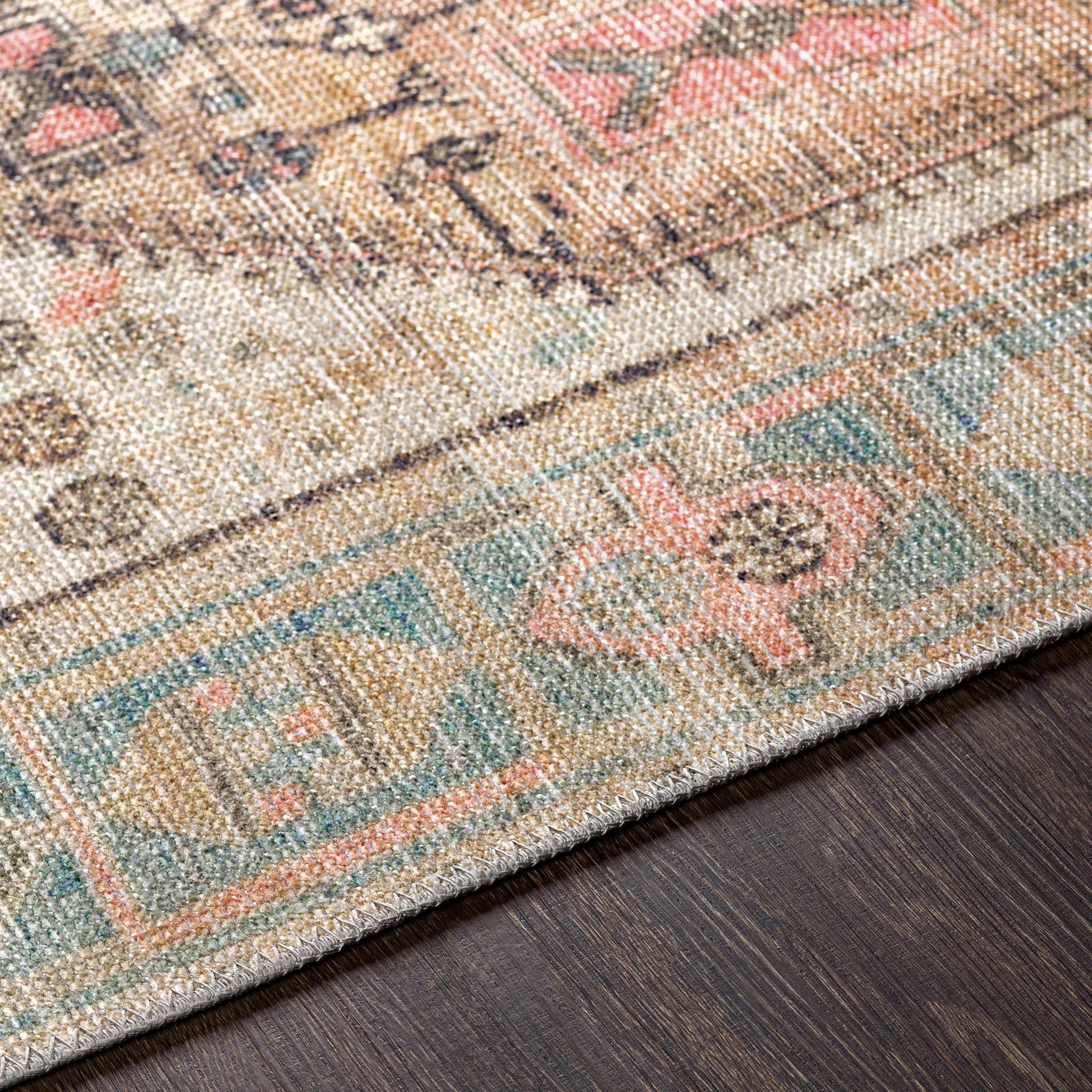 Close-up of a patterned rug with multicolor design on a wooden floor.