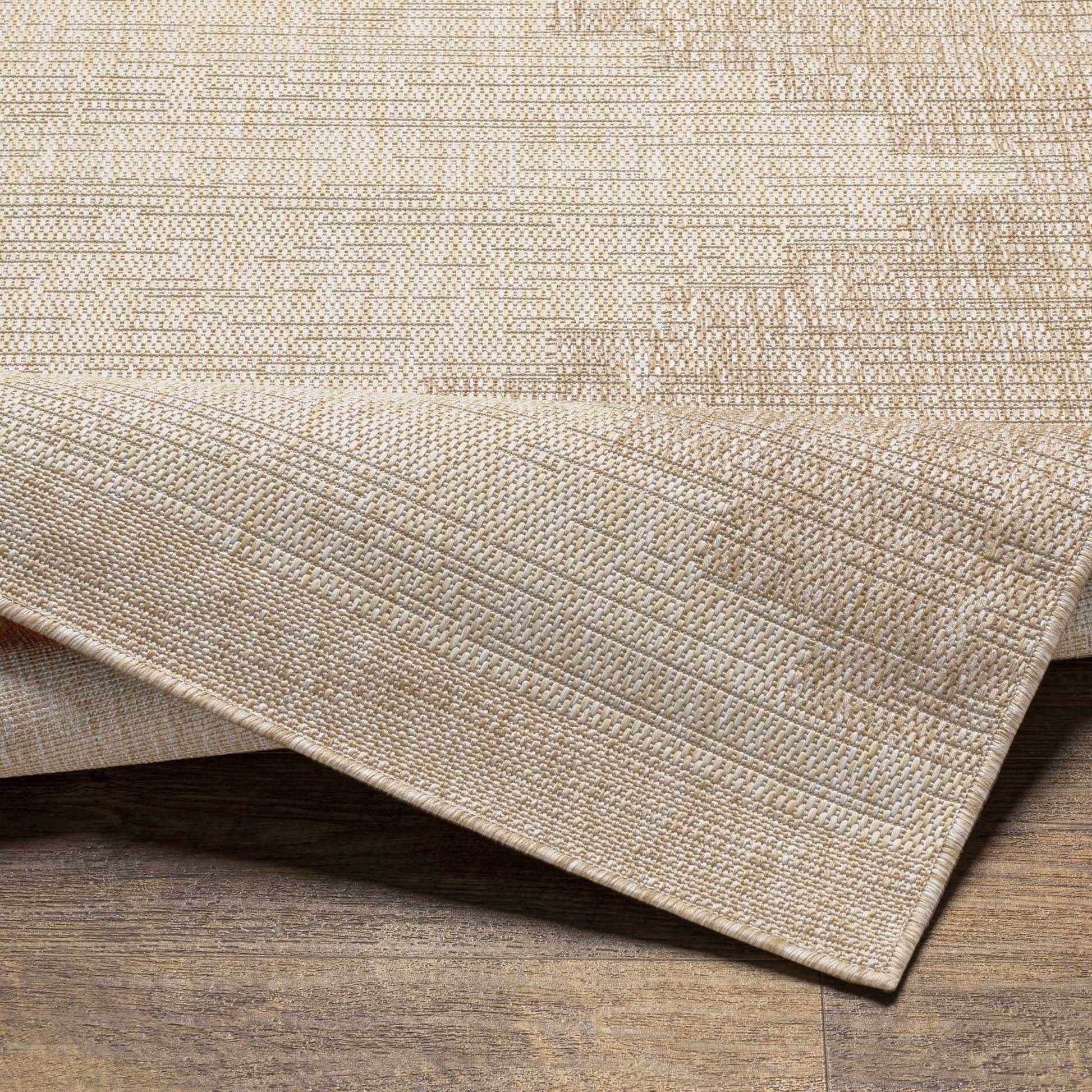 Close-up of a textured beige rug on a wooden floor