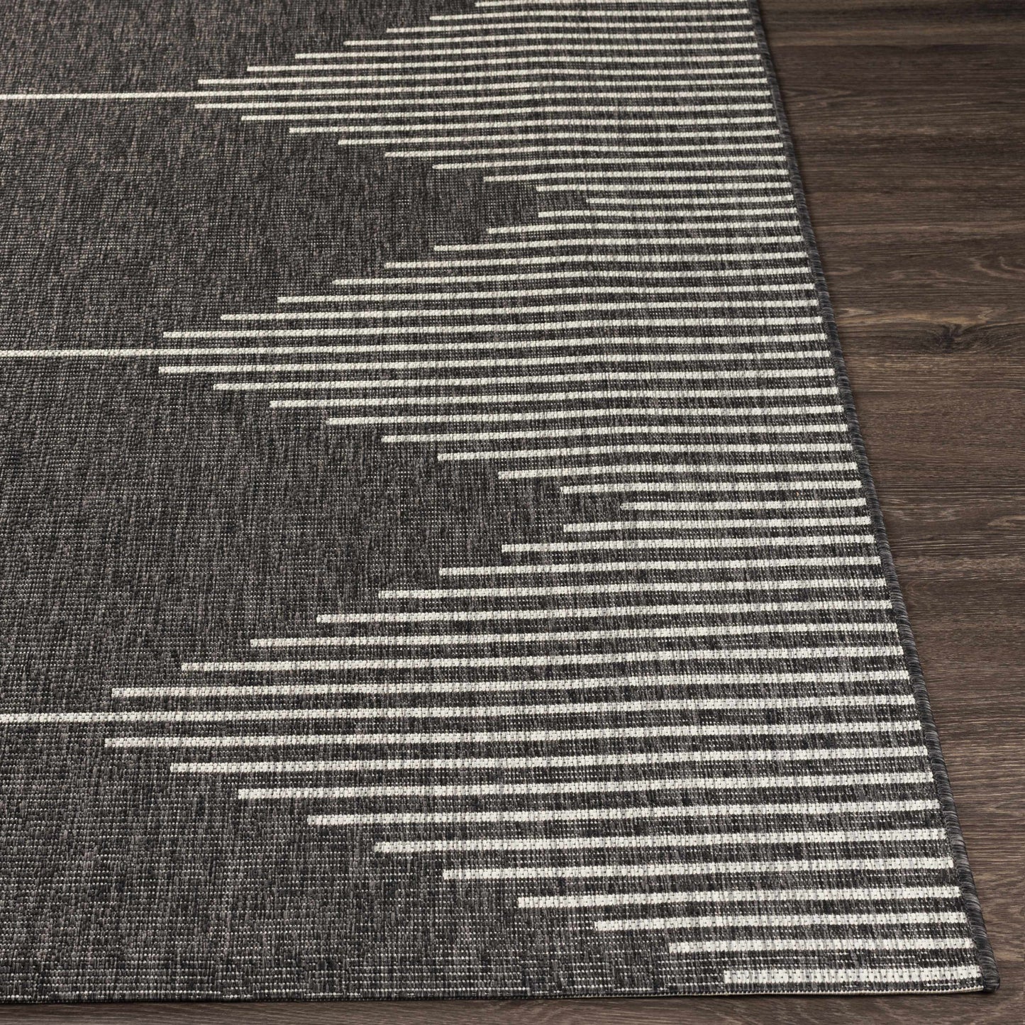 Gray and white striped rug on a wooden floor